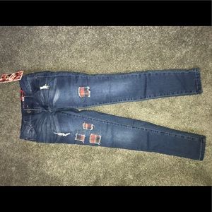 Navy blue jeans that have unique patches in them